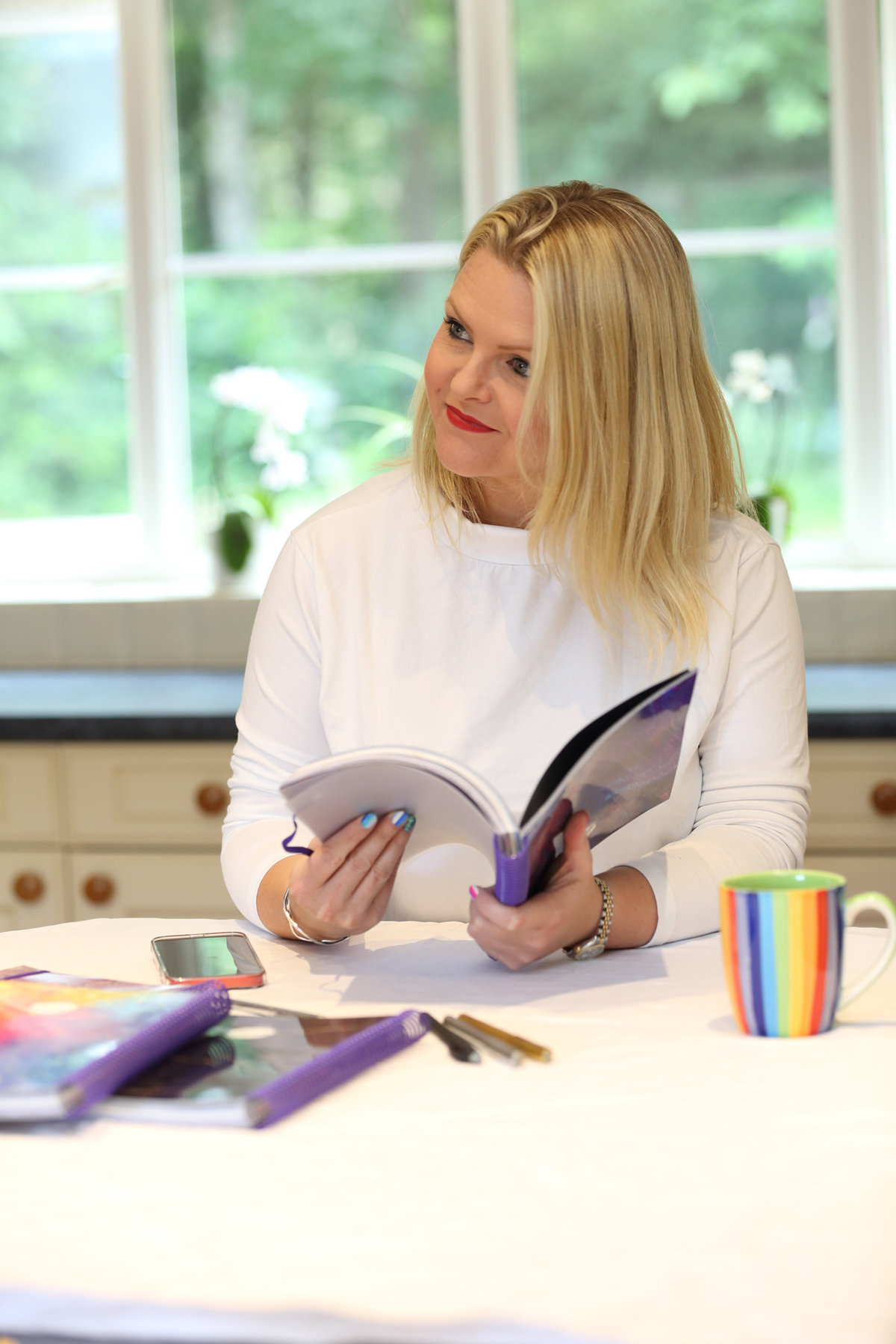 Sophie reading through a finished planner at her kitchen table