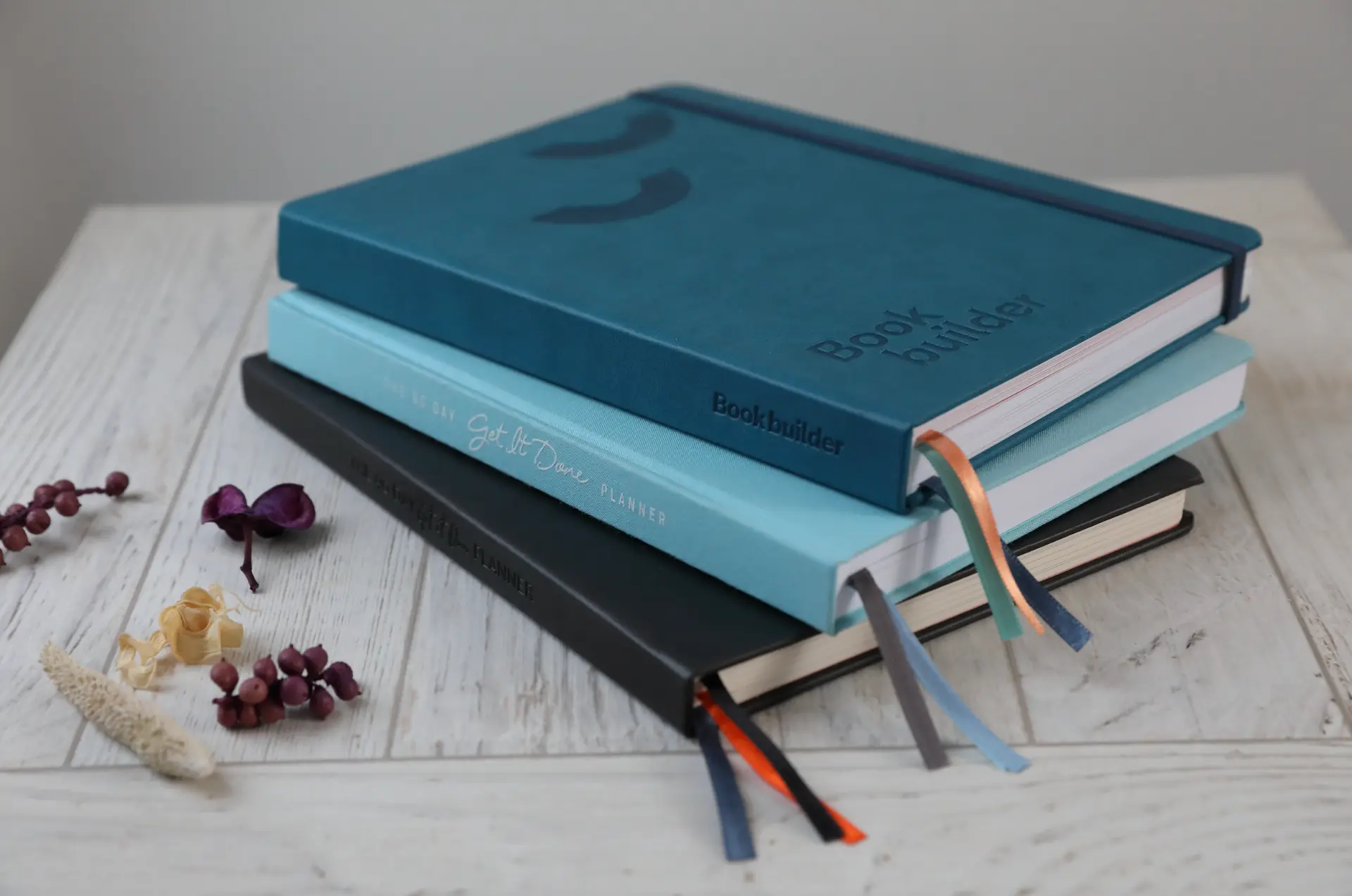 A Bookbuilder journal stacked with Get It Done planners
